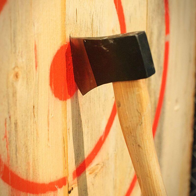 close up of axe stuck in a wooden bullseye